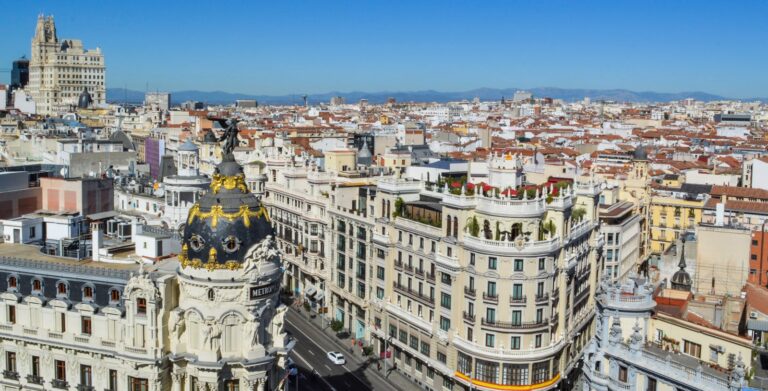 Stunning aerial view of Madrid's Gran Via showcasing historic architecture under clear blue skies.
